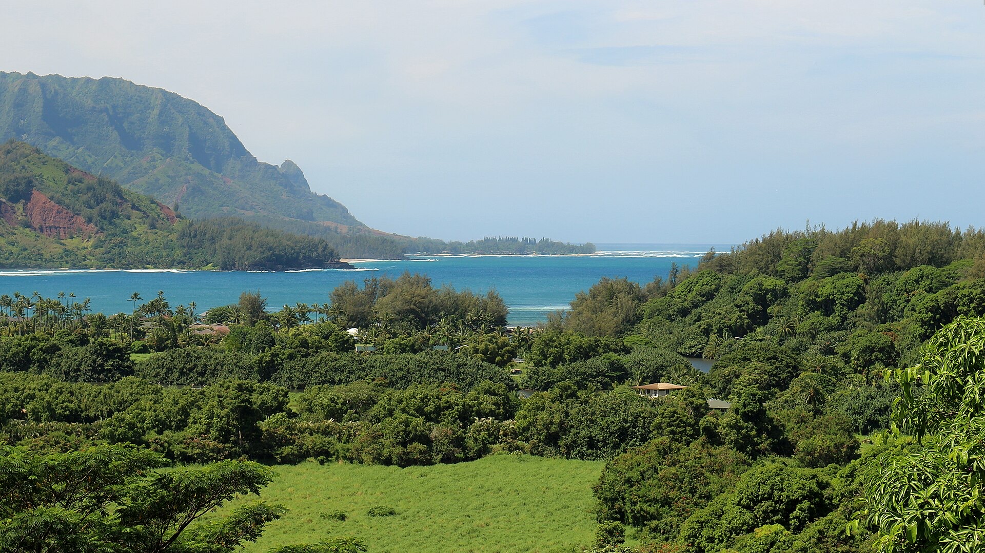 Hanalei Bay on Kauai's north shore seen from the Princeville side, with green mountains behind